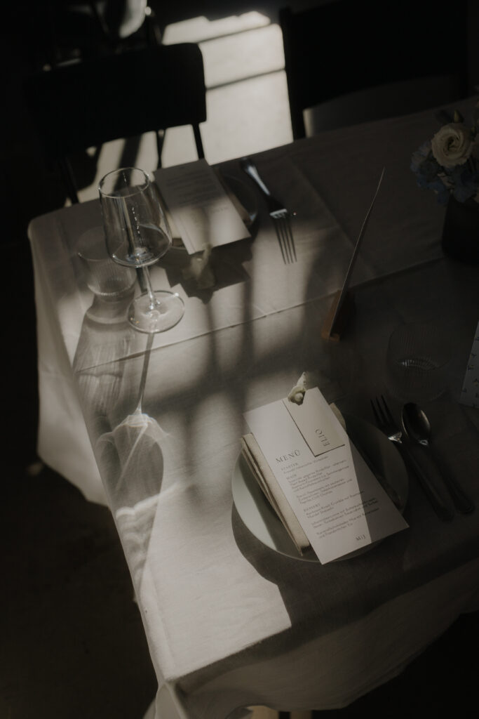 Atmospheric table setting with a menu card and natural light in a wedding venue in Hamburg