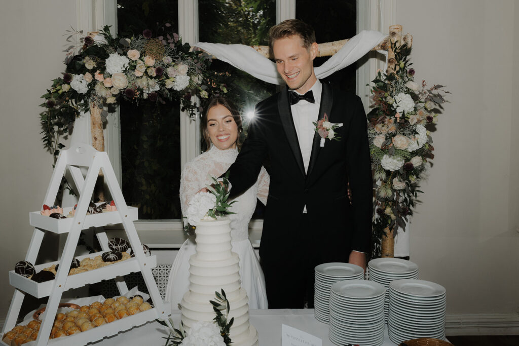 Brautpaar beim Tortenanschnitt in der Hochzeitslocation Gut Bliestorf geplant von Hochzeitsplanerin Dilan Kaya