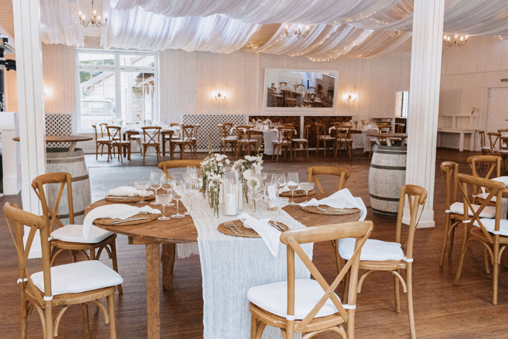 Festsaal im Landhaus Westerhof mit Stoffhimmel, Holztischen und stilvollem Dinner-Setup