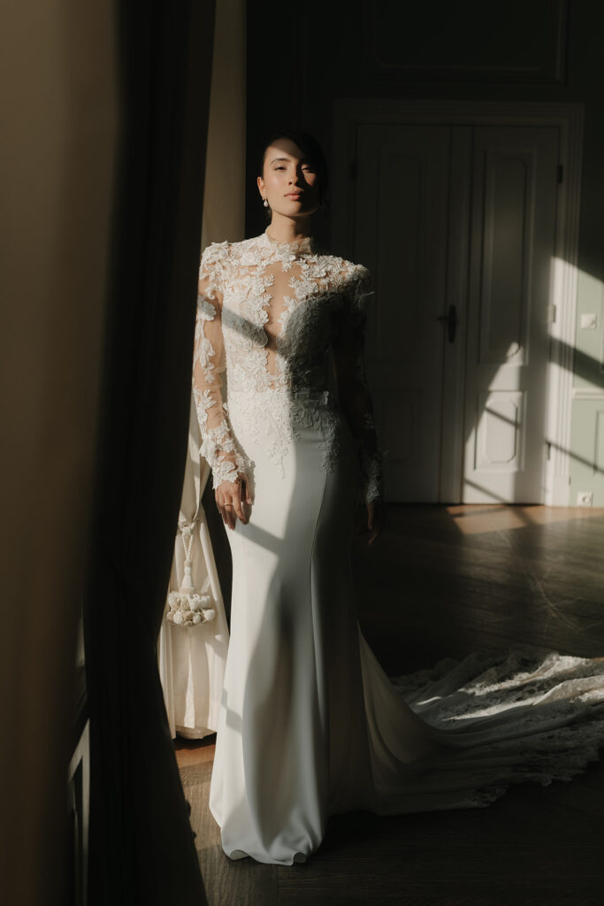 Braut im enganliegenden Hochzeitskleid mit Spitze, stehendes Portrait im Licht-Schatten-Spiel – Hochzeitsfotograf Hamburg