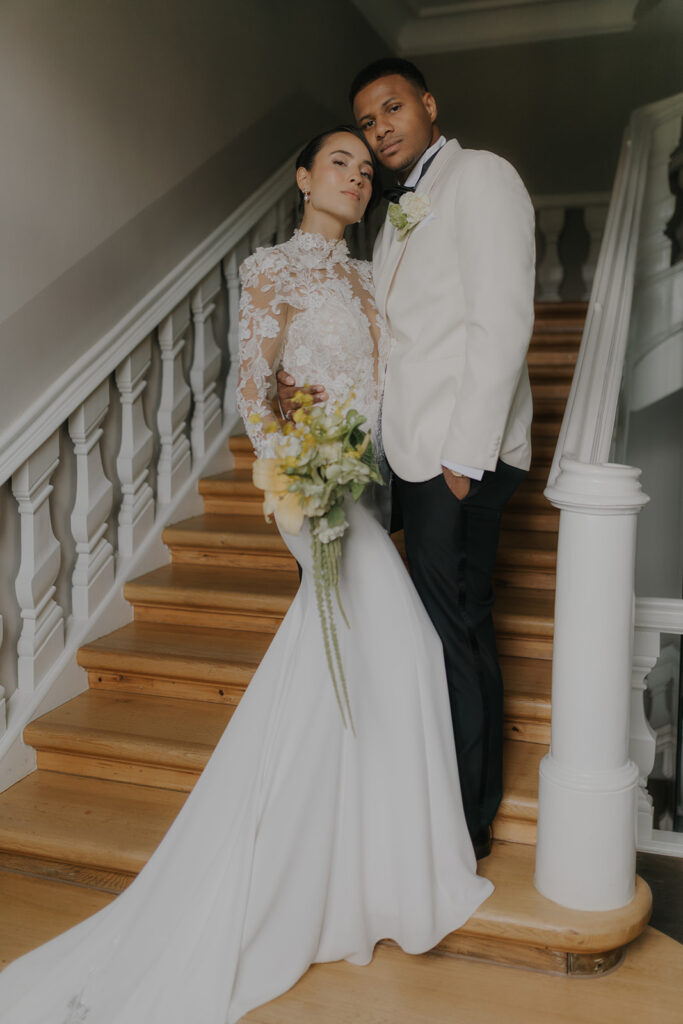 Bridal couple in modern wedding attire on the stairs of a stylish venue in Hamburg