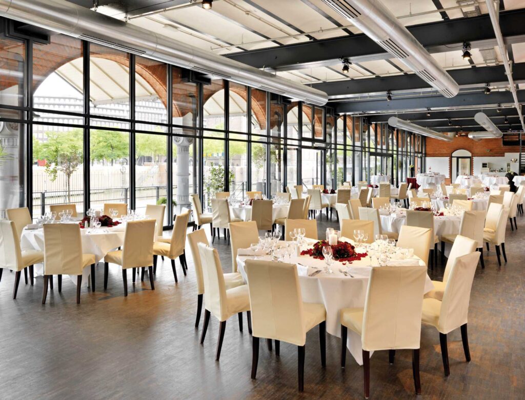Hochzeitsdinner im ehemaligen Hauptzollamt Hamburg mit runden Tischen und Industriearchitektur