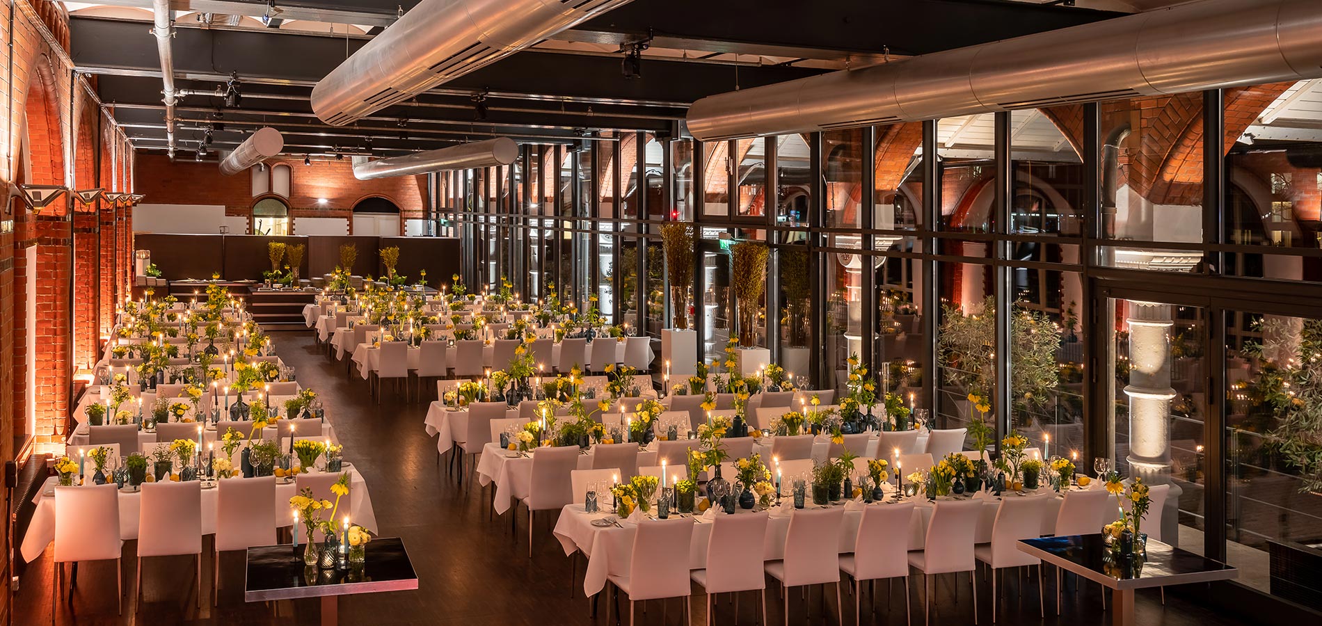 Evening wedding atmosphere in the former Hamburg Main Customs Office with long tables and lighting