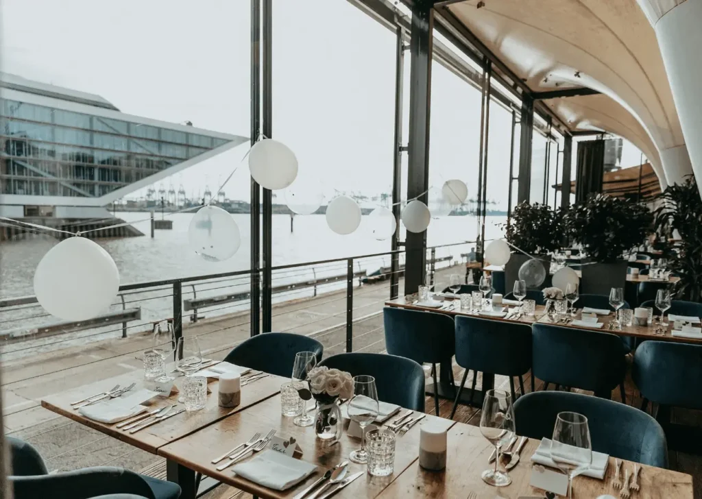 Eventlocation am Kai Hamburg mit gedeckten Tischen und Blick auf die Elbe und den Hafen für stilvolle Hochzeiten