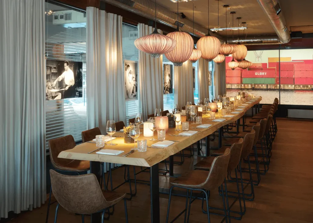 Lange Holztafel mit Kerzenlicht und eleganter Tischdekoration in der Eventlocation am Kai für ein stilvolle Hochzeit