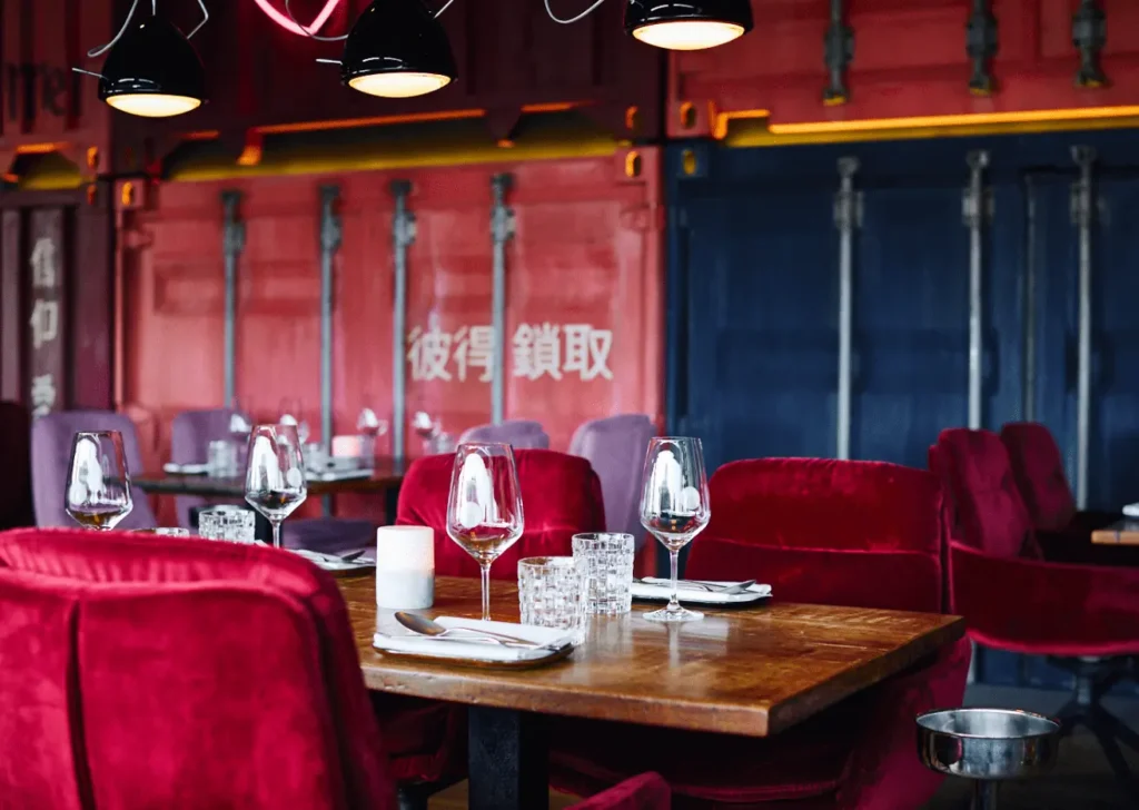 Urbanes Interieur der Eventlocation am Kai Hamburg mit roten Samtstühlen und Container-Design für moderne Hochzeiten