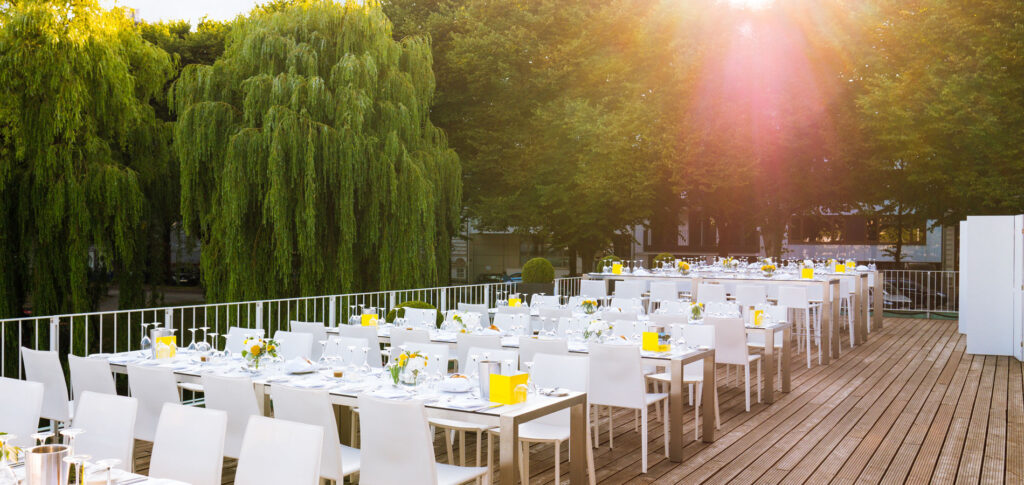 Große Alsterterrasse des Hamburger & Germania Ruder Clubs mit langen Hochzeitstafeln und Abendsonne für ein elegantes Dinner am Wasser