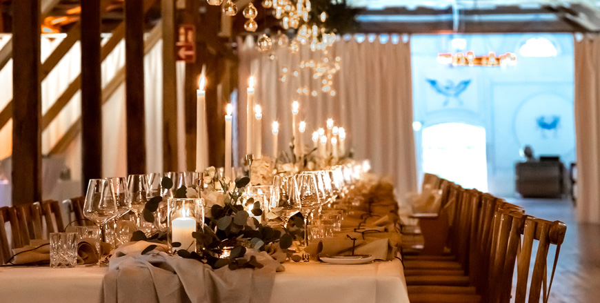 Gut Pronstorf elegant gedeckte lange Tafel im Kutschstall für eine stilvolle Hochzeitsfeier