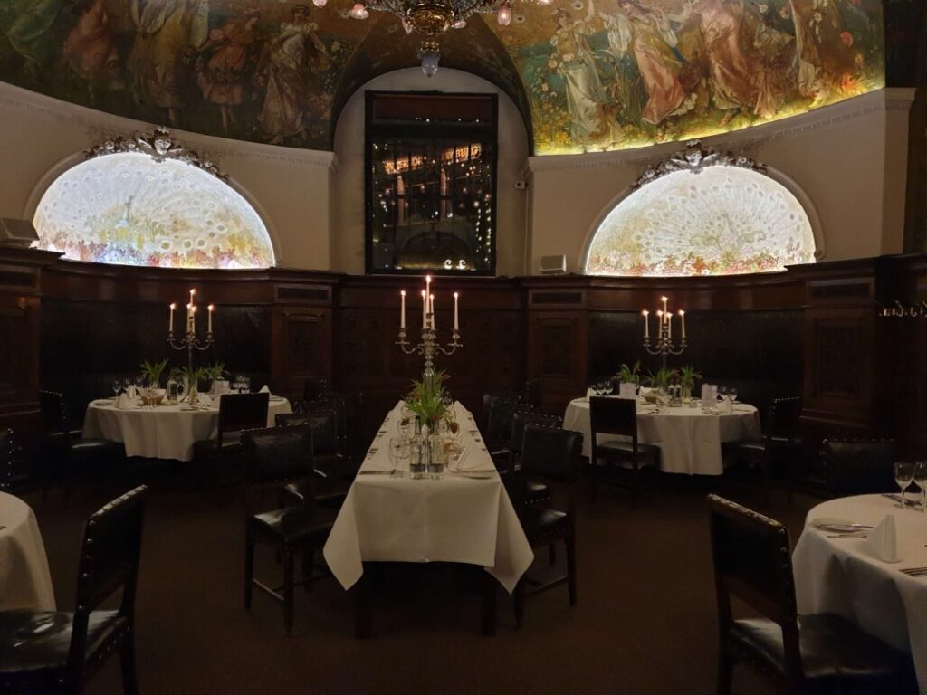 Raum Rose im Parlament Hamburg mit imposantem Kronleuchter und eleganter Tischgestaltung für eine intime Hochzeit im Rathaus