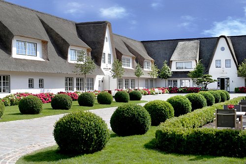 Innenhof des Severin*s Sylt mit Reetdachhäusern und gepflegter Gartenanlage